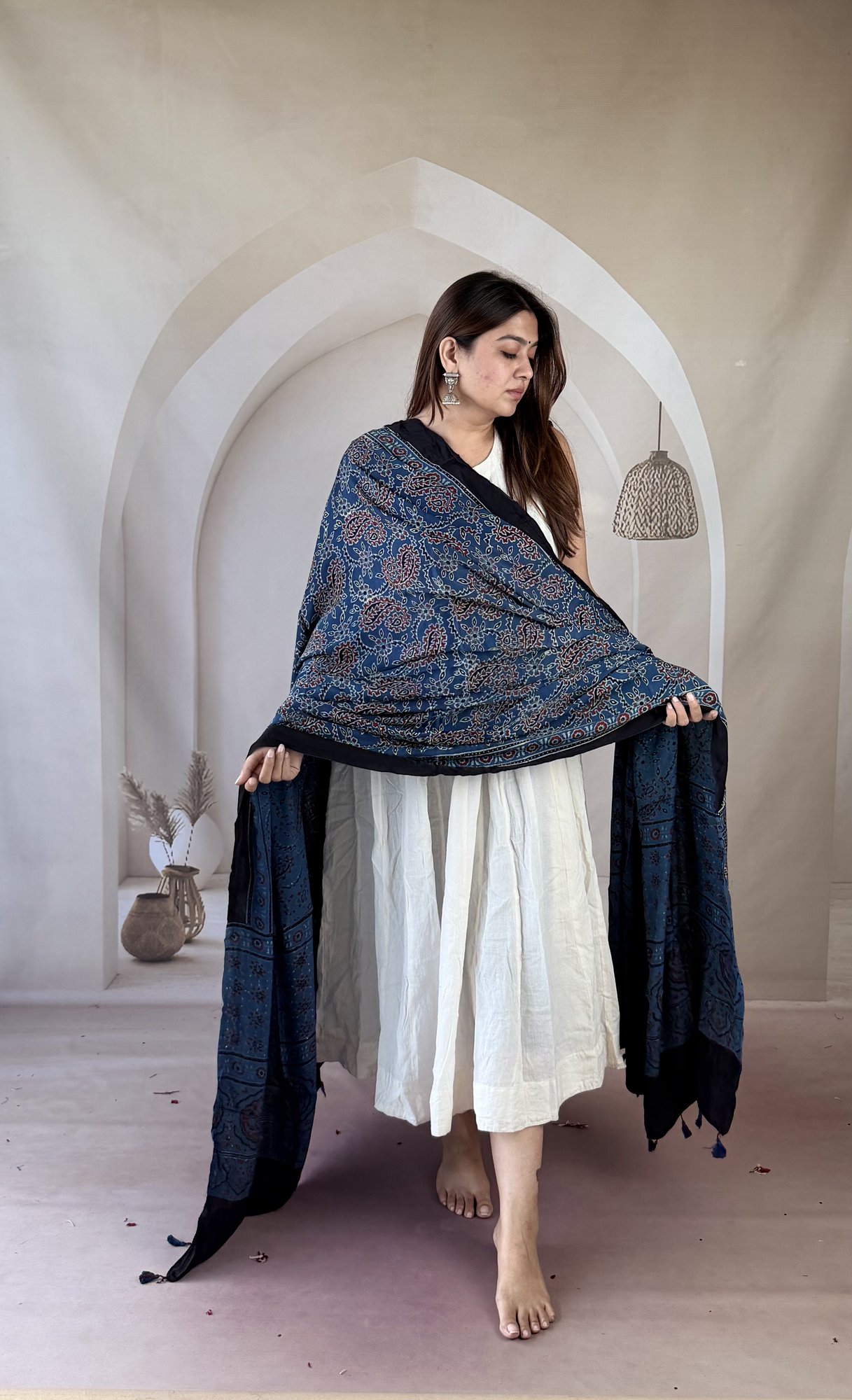 indigo-ajrakh-modal silk-dupatta-paisley-creeper-2 Indigo Ajrakh modal silk dupatta draped over both arms showing geometric star palla and tassels